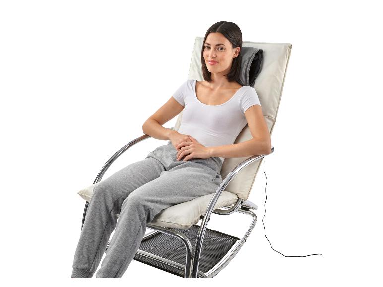 Kobieta siedzi w białym fotelu relaksacyjnym z poduszką do masażu.