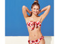 Kobieta w czerwonym bikini w kwiaty na tle niebieskiego nieba.