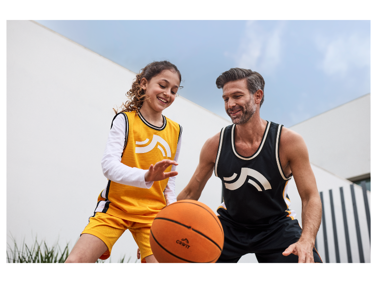 Ojciec i córka grają w koszykówkę z piłkami Crivit.