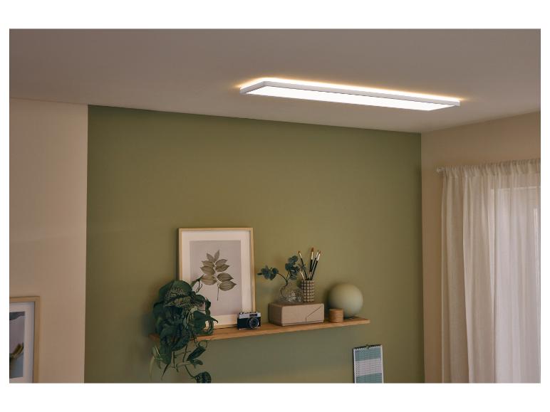 Lampa sufitowa LED w salonie z zieloną ścianą i półką z dekoracjami.