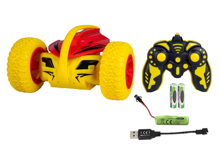 Żółto-czerwony samochód-zabawka zdalnie sterowany z pilotem, bateriami i kablem do ładowania.
