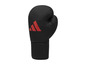 Czarna rękawica bokserska z czerwonym logo Adidas.