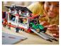 Uśmiechnięte dziecko bawi się zestawem LEGO z transporterem samochodów wyścigowych.