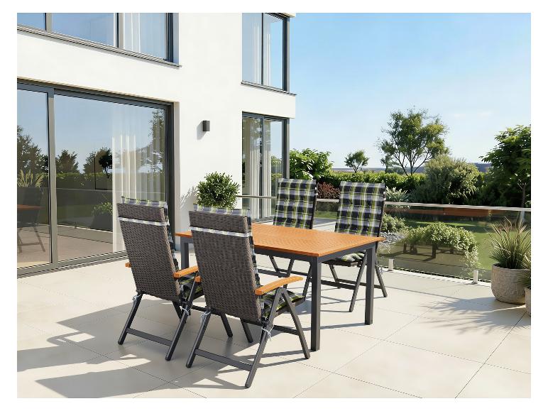 Zestaw obiadowy na patio z drewnianym stołem i czterema krzesłami z poduszkami w kratę na nowoczesnym tarasie.