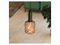 Lampa wisząca z żarówką filamentową w salonie z zieloną sofą i rośliną.