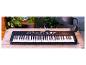 Czarny keyboard Yamaha PSR-E363 na drewnianym stole.