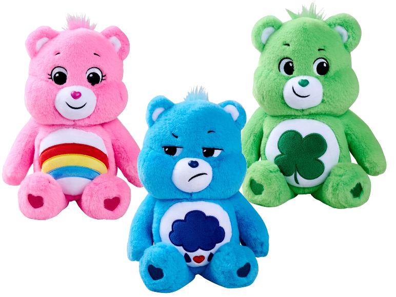 Trzy pluszowe misie Care Bears: różowy, niebieski i zielony, z charakterystycznymi znaczkami na brzuchu.