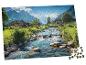 Częściowo ukończone puzzle przedstawiające górską wioskę z rzeką i domami.