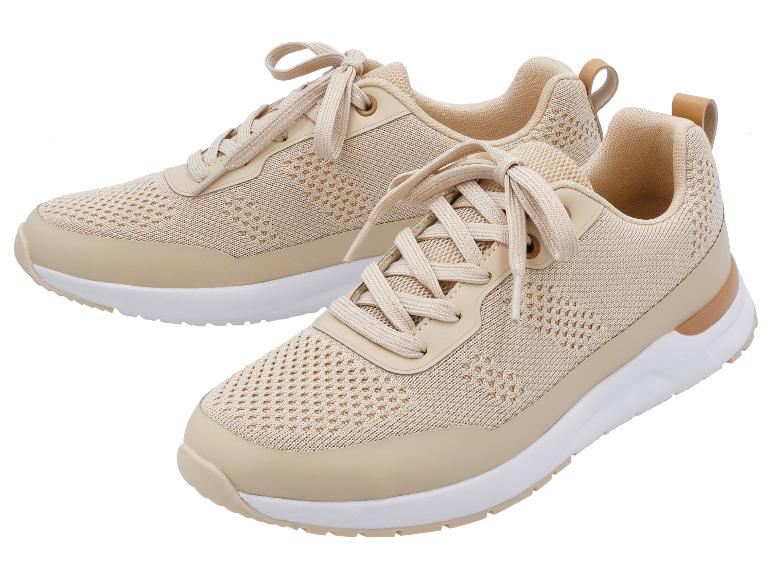 Dwa beżowe sneakersy ze sznurowadłami, białymi podeszwami i jasnobrązowymi detalami.