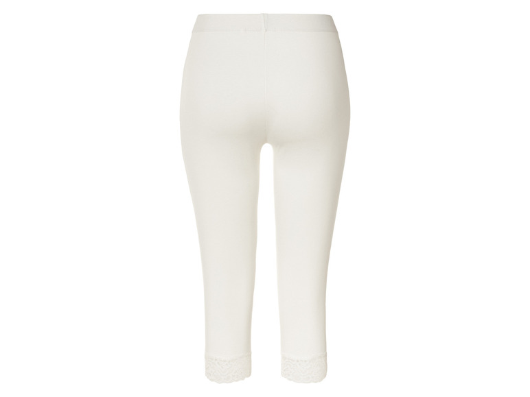 Białe legginsy z koronką na dole.