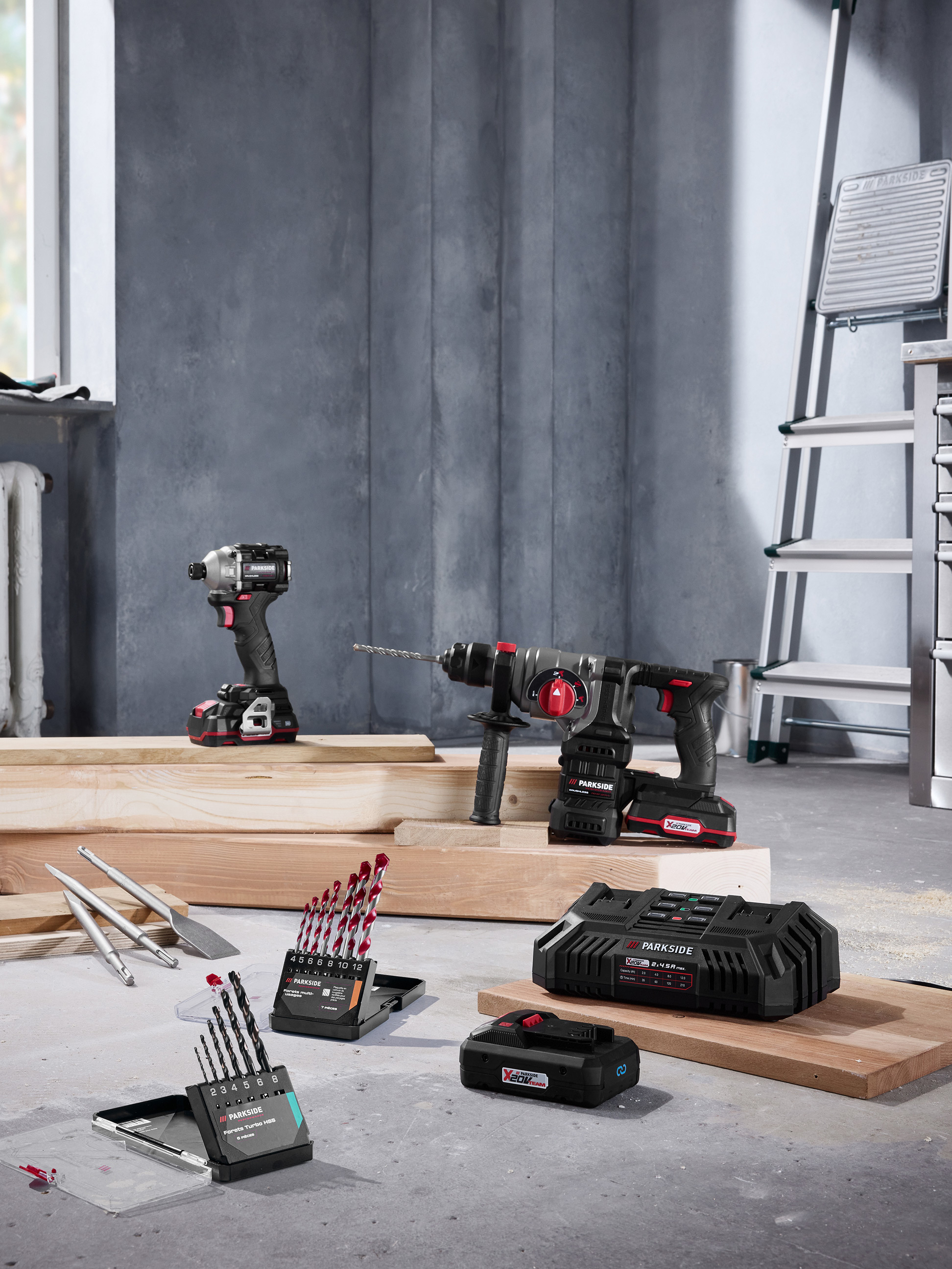 Elektronarzędzia Parkside z wiertarkami, wiertłami i ładowarką w środowisku budowlanym.