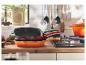 Trzy patelnie Le Creuset ułożone na sobie w kuchni.
