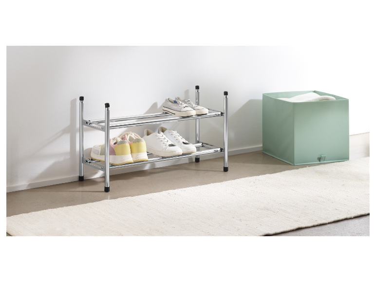 Dwupiętrowy metalowy stojak na buty z butami na nim.