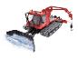 Czerwony ratrak PistenBully 600 z pługiem i ramieniem podnoszącym.