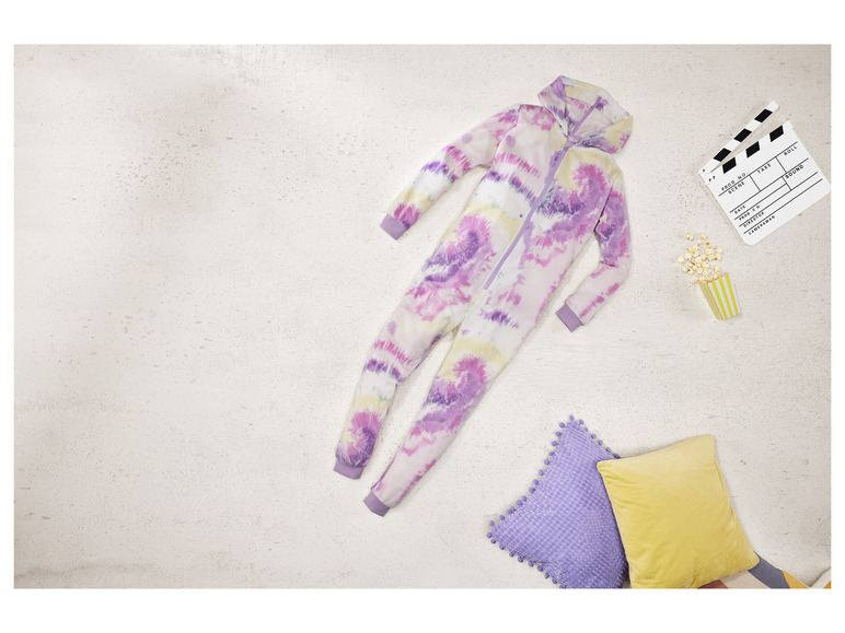 Komplet jednoczęściowy w stylu tie-dye, poduszki i popcorn na jasnym tle.