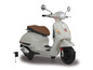 Biały elektryczny skuter Vespa z ładowarką.