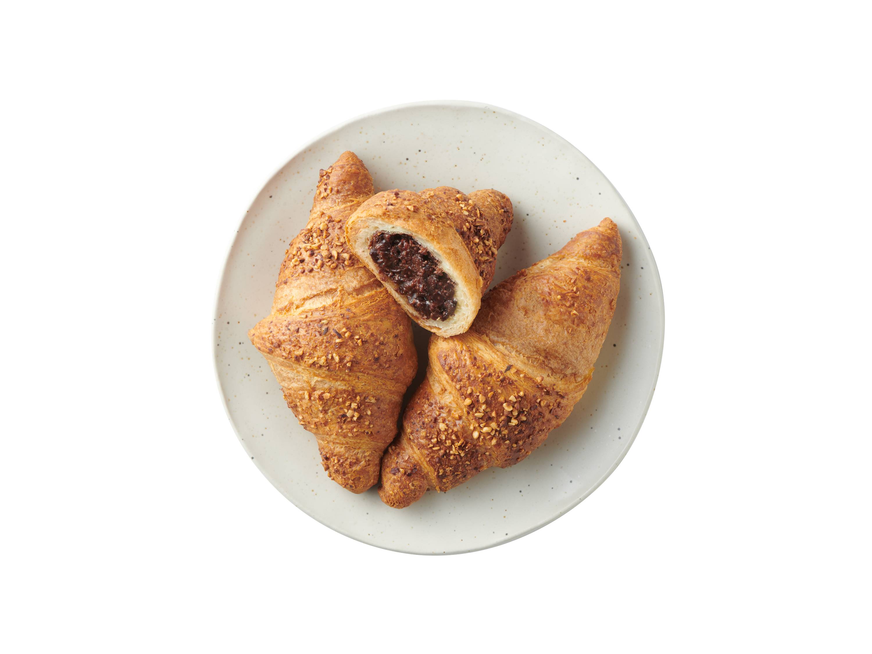 Croissanty z nadzieniem czekoladowym i posypką orzechową na talerzu.