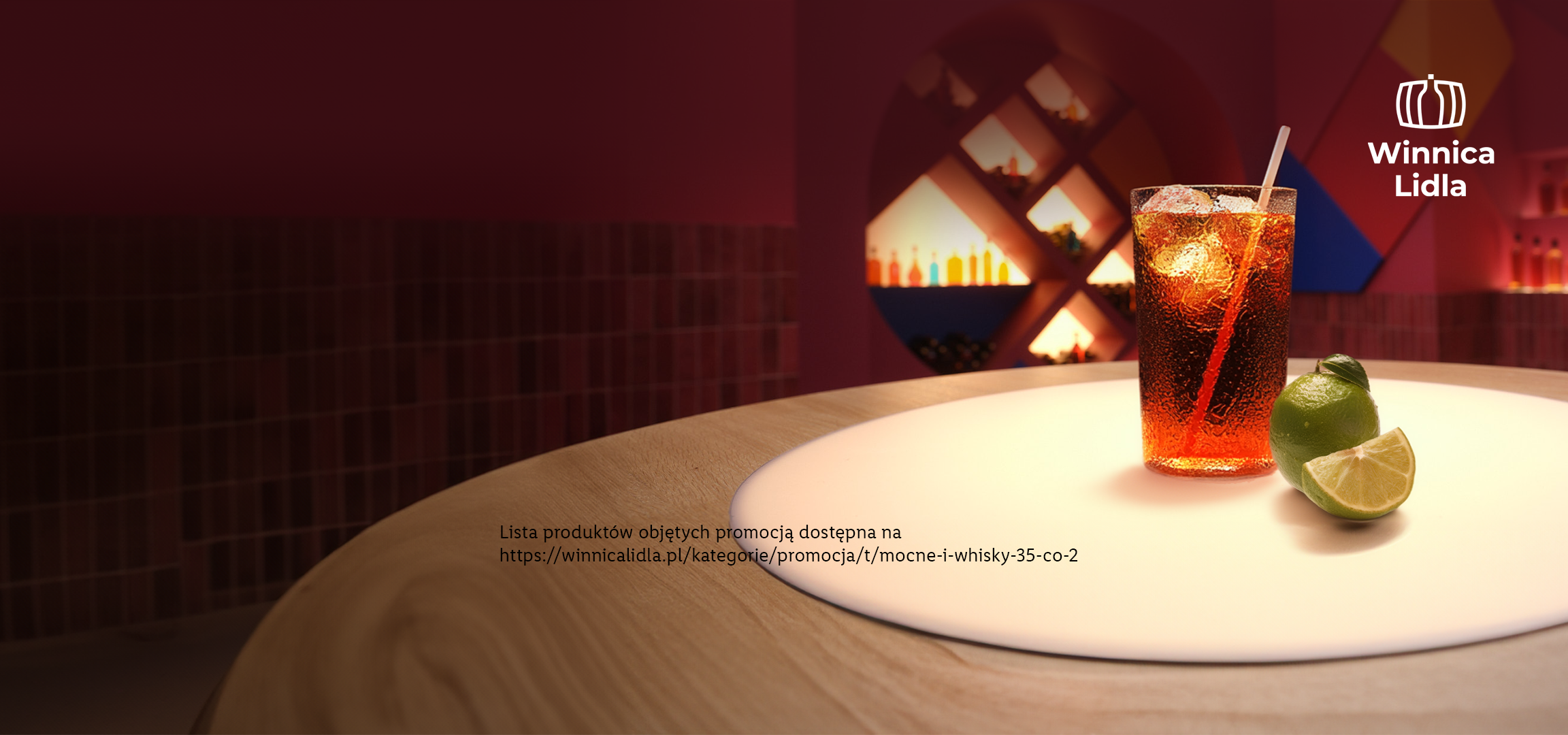 Drink z lodem i limonką na stole, z logo Winnica Lidla i adresem strony internetowej.