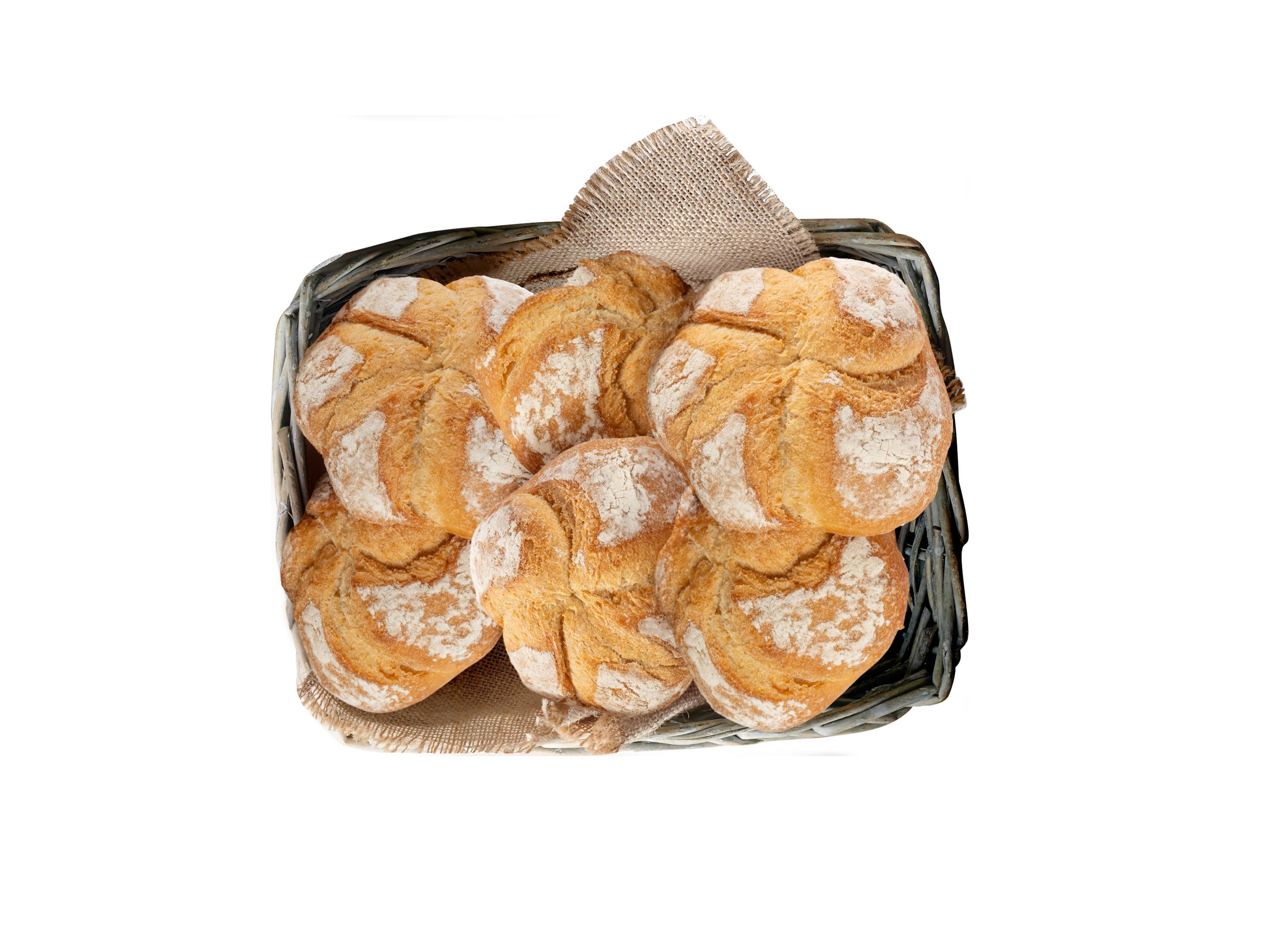 Świeże, okrągłe bułki posypane mąką, ułożone w wiklinowym koszyku wyłożonym jutą.