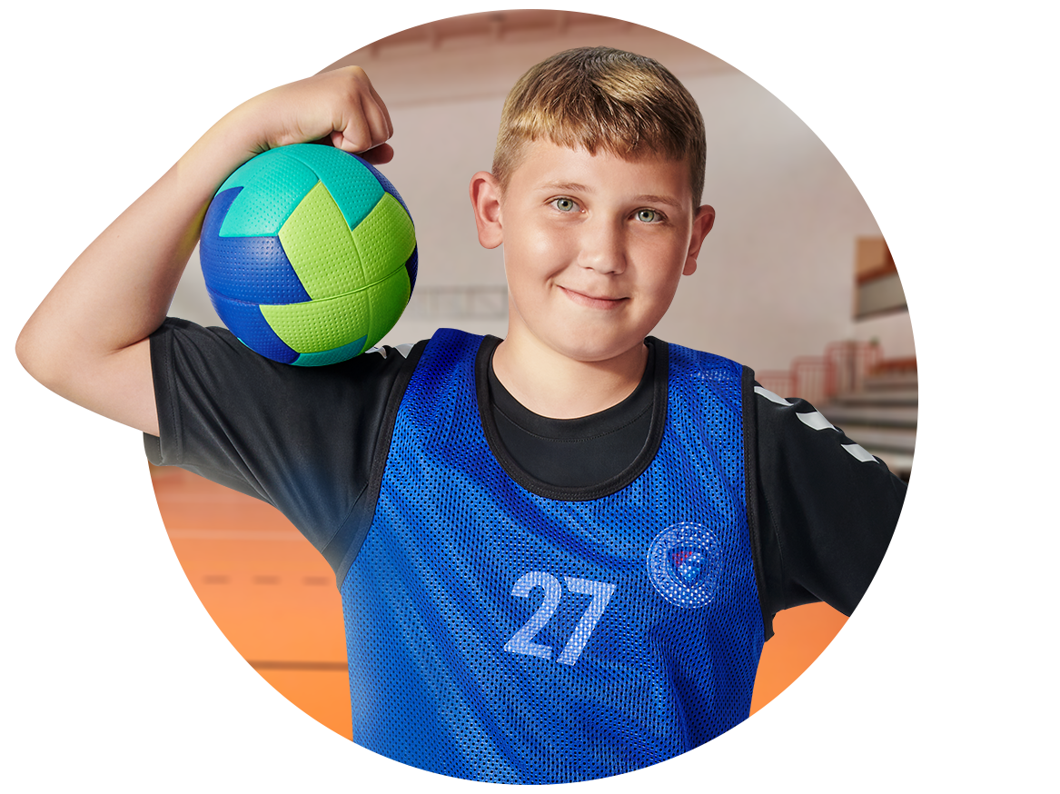 Chłopiec w niebieskiej koszulce z numerem 27 trzyma piłkę.