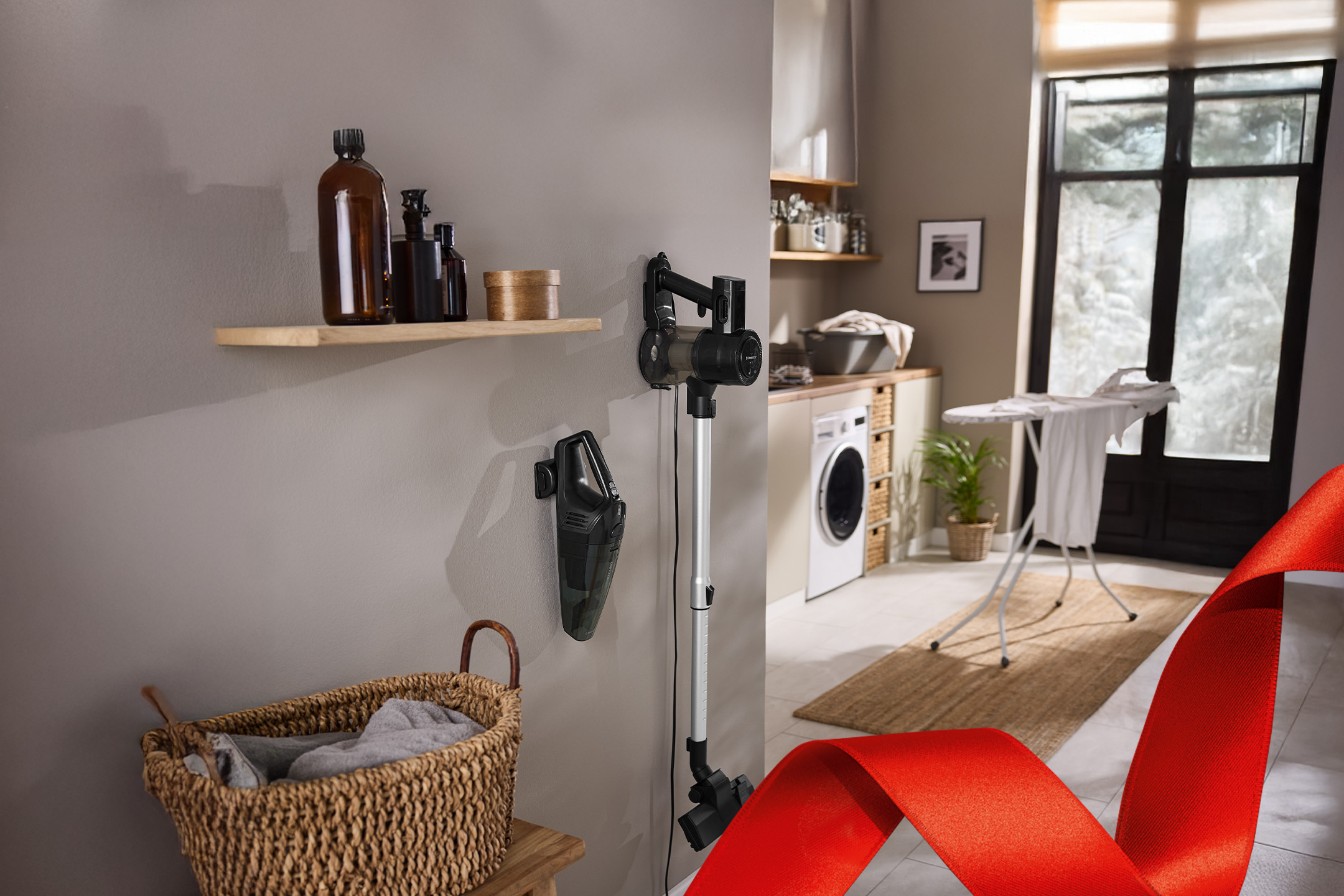 Odkurzacz pionowy i ręczny w pralni z koszem na pranie.