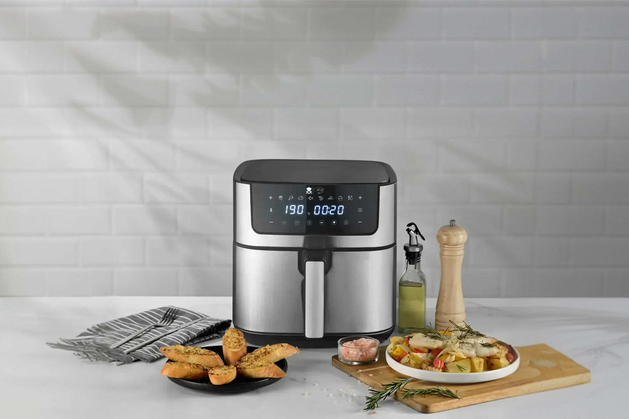 Srebrna frytkownica beztłuszczowa z czosnkowym pieczywem i pieczonymi warzywami.