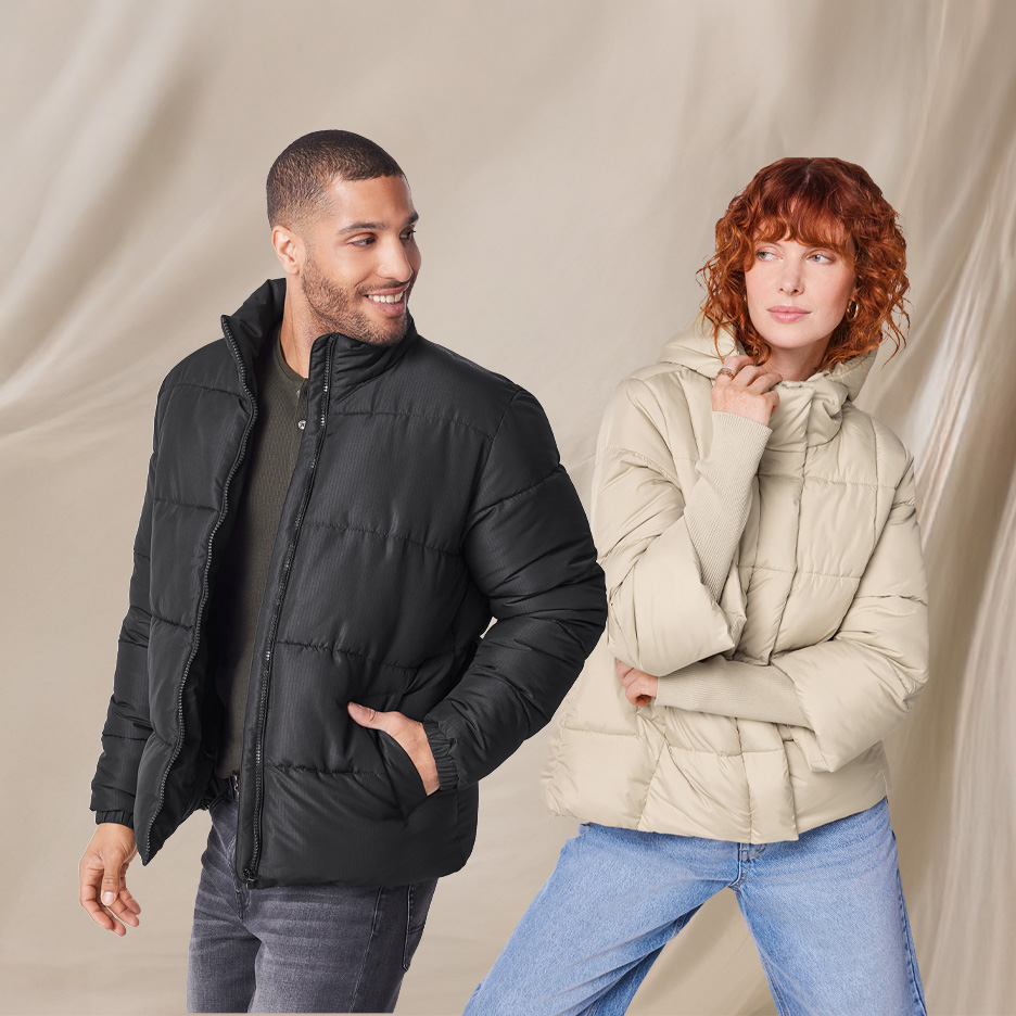 Mężczyzna w czarnej kurtce puchowej i kobieta w beżowej kurtce puchowej.