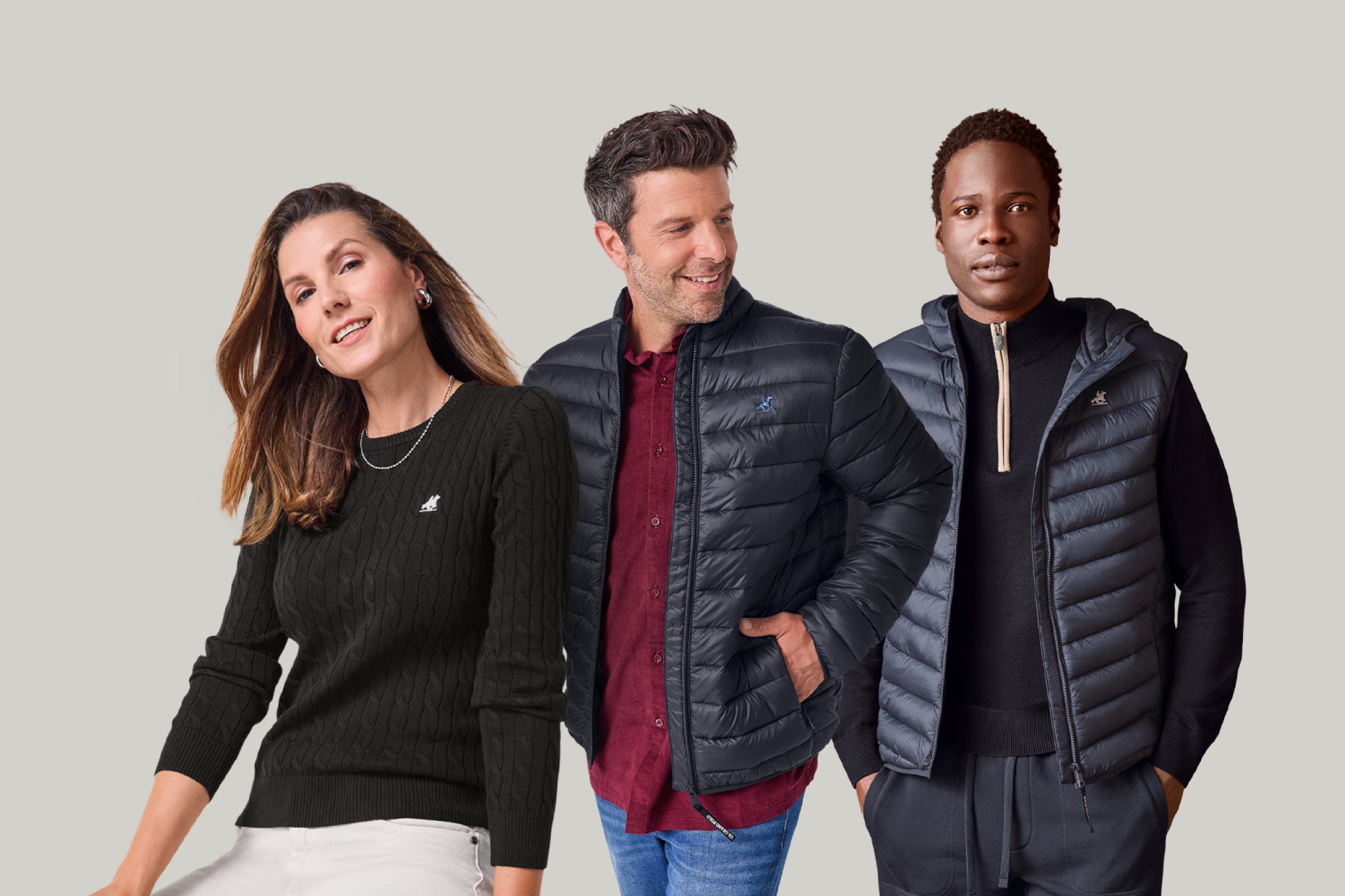 Trzy osoby w kurtkach puchowych i swetrach