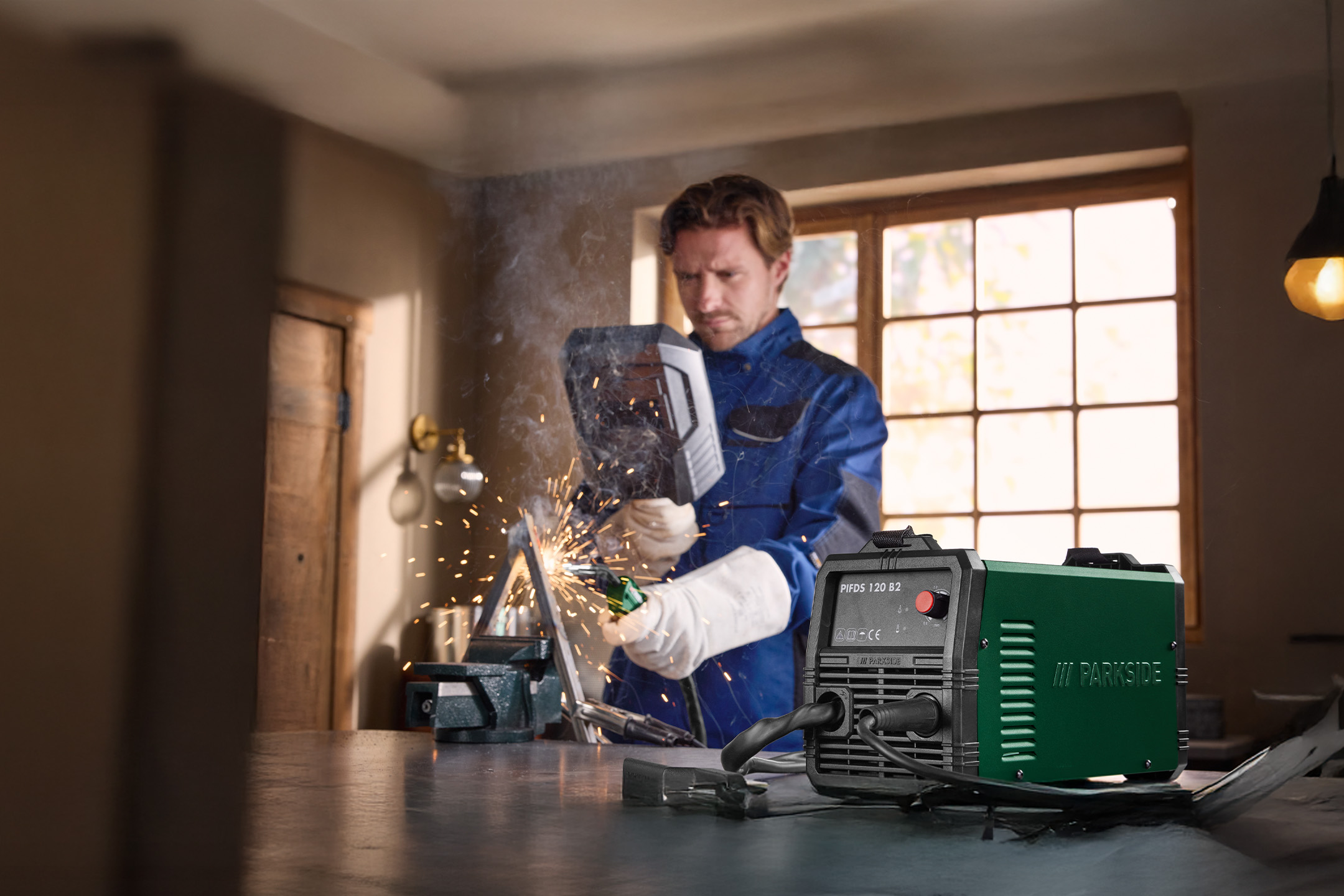 Mężczyzna spawa, używając spawarki inwertorowej.