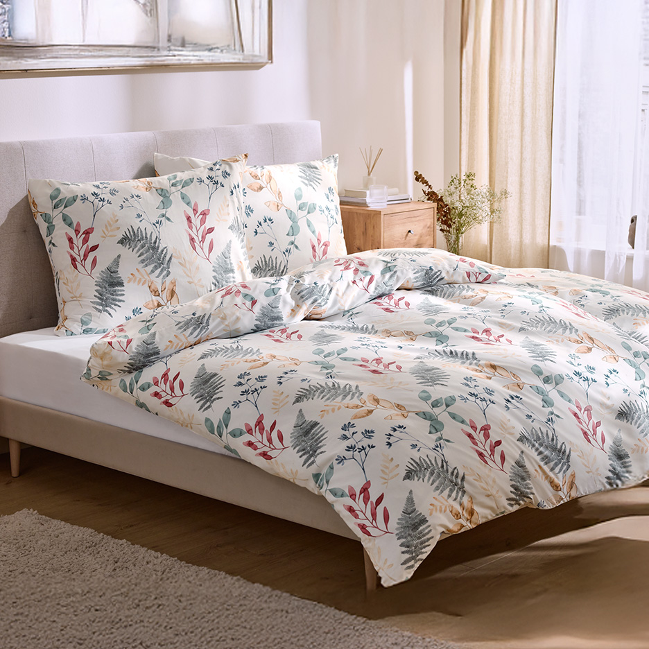 Pościel z motywem liści i roślin na łóżku w sypialni.