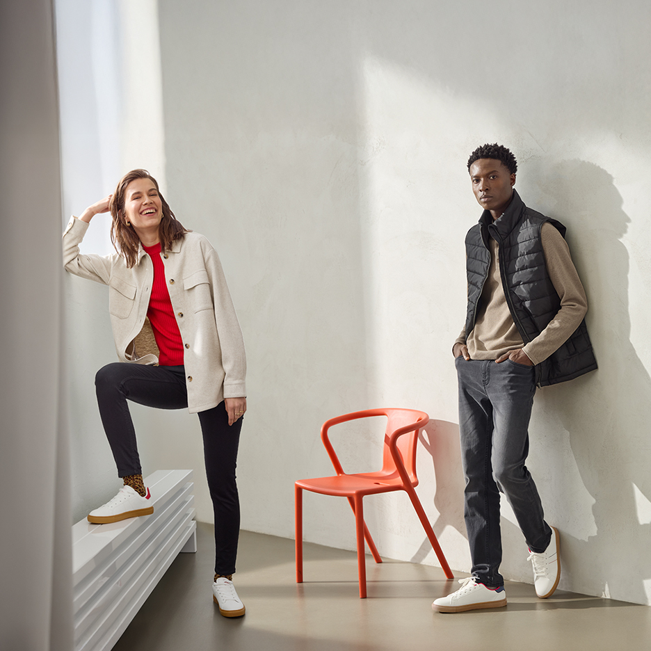 Kobieta w beżowej koszuli i czerwonym swetrze, mężczyzna w czarnej kamizelce i beżowym swetrze.