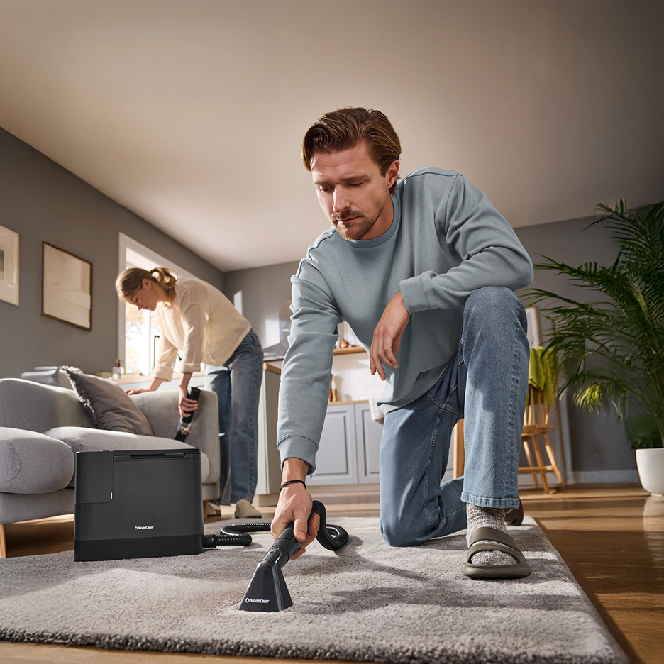 Para czyści dywan i sofę odkurzaczem piorącym w salonie.