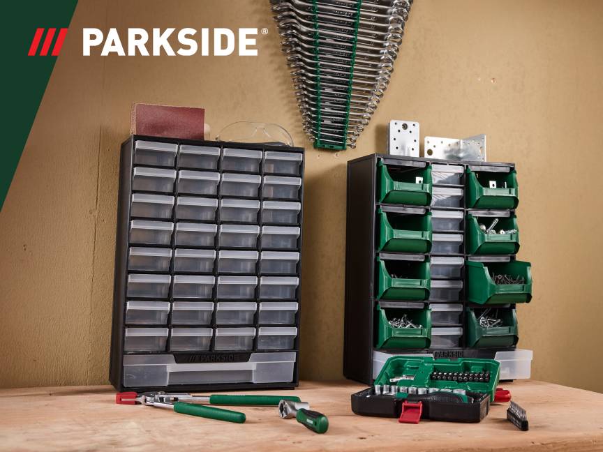 Szafki z szufladami i pojemnikami na narzędzia i drobne elementy na drewnianym stole.