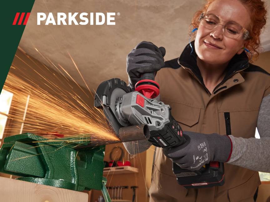 Kobieta używająca szlifierki kątowej do cięcia metalu, z iskrzącym się efektem.