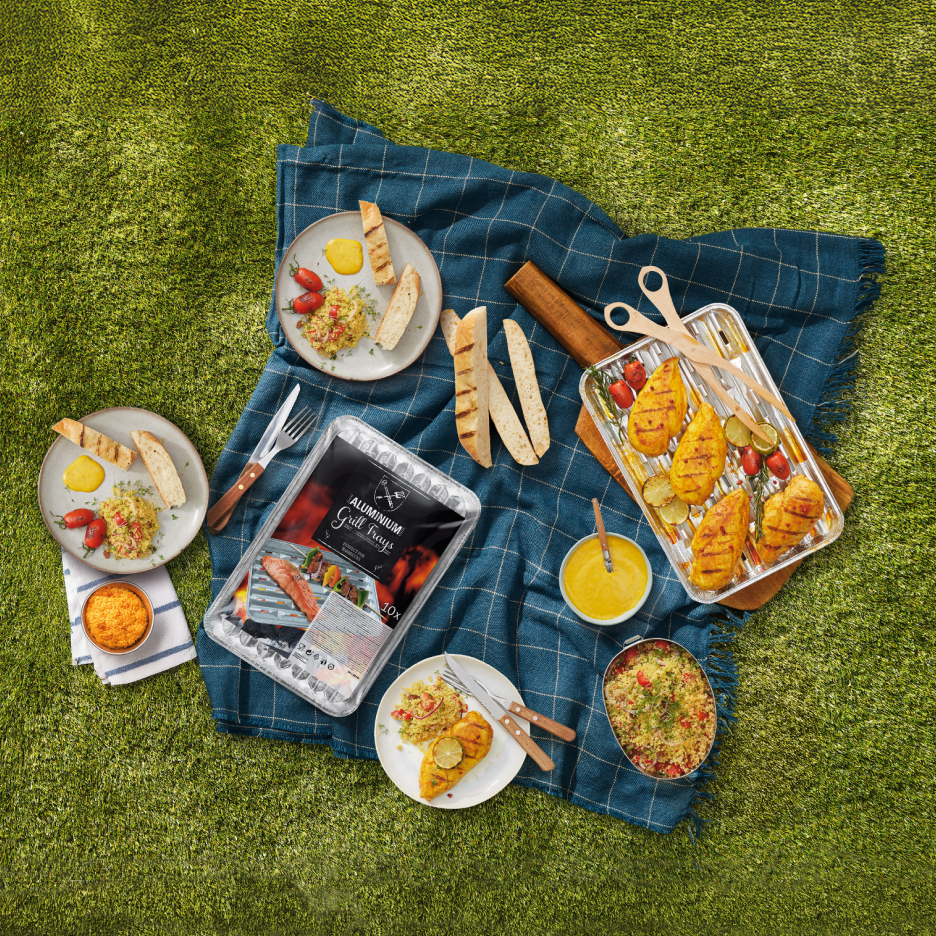 Piknik z grillowanym kurczakiem, kuskusem i pieczywem, z aluminiowymi tackami grillowymi.