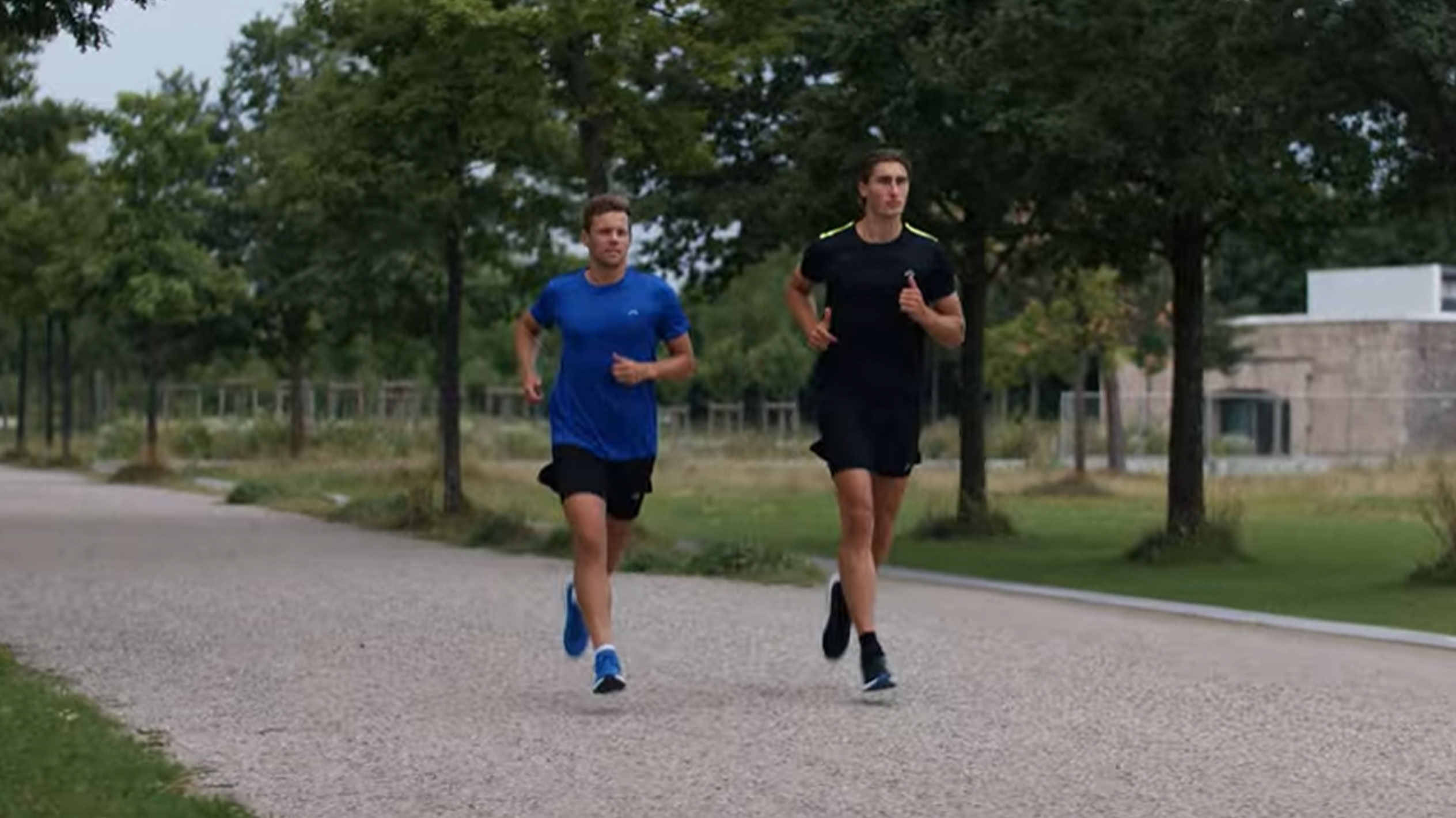Dwóch mężczyzn biegnących w sportowych koszulkach i szortach