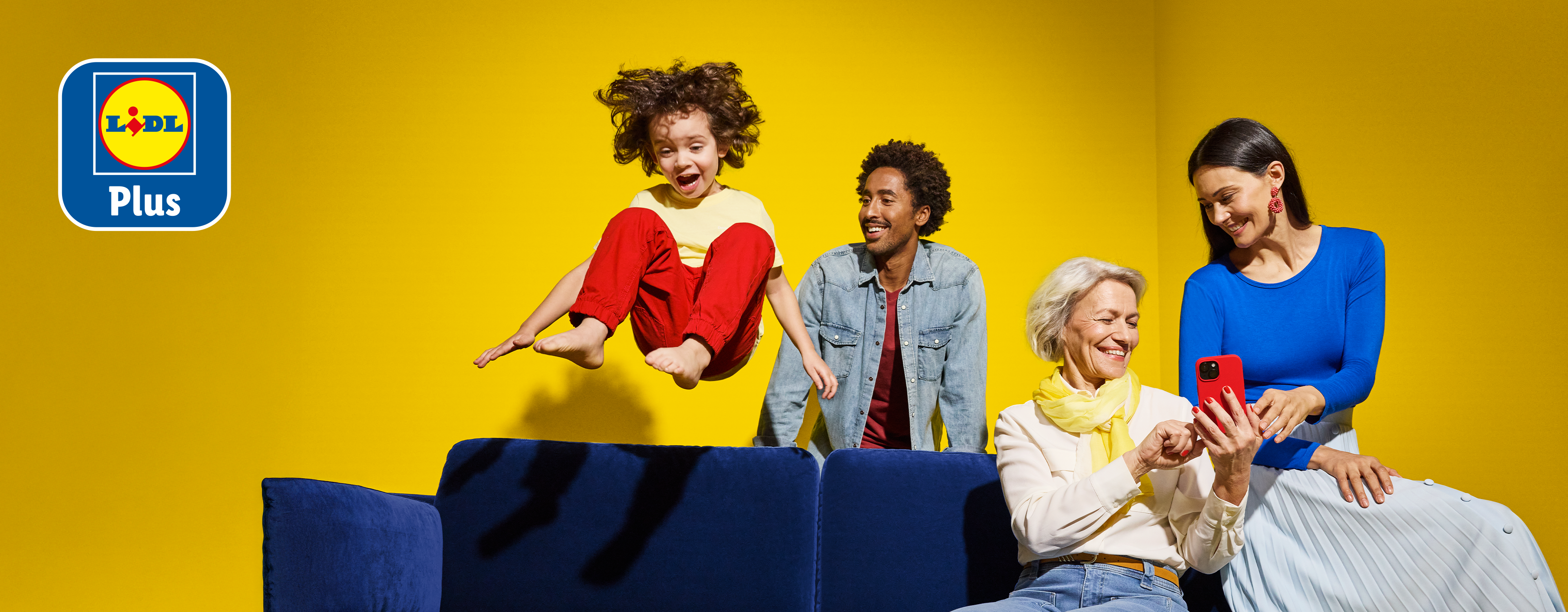 Rodzina skacząca na kanapie, z logo Lidl Plus w lewym górnym rogu.