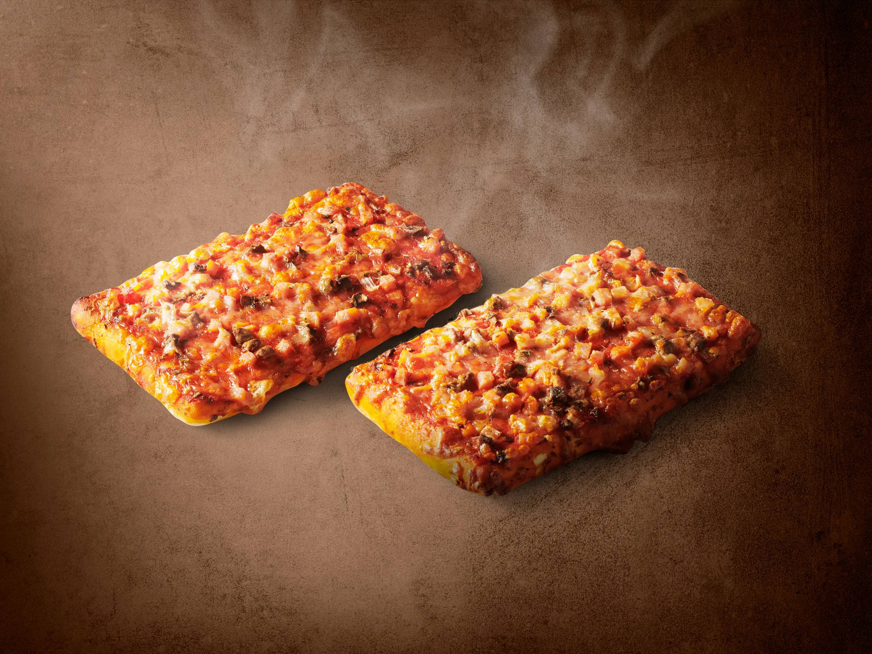 Dwie gorące, prostokątne pizze z serem i mięsem na brązowym tle.